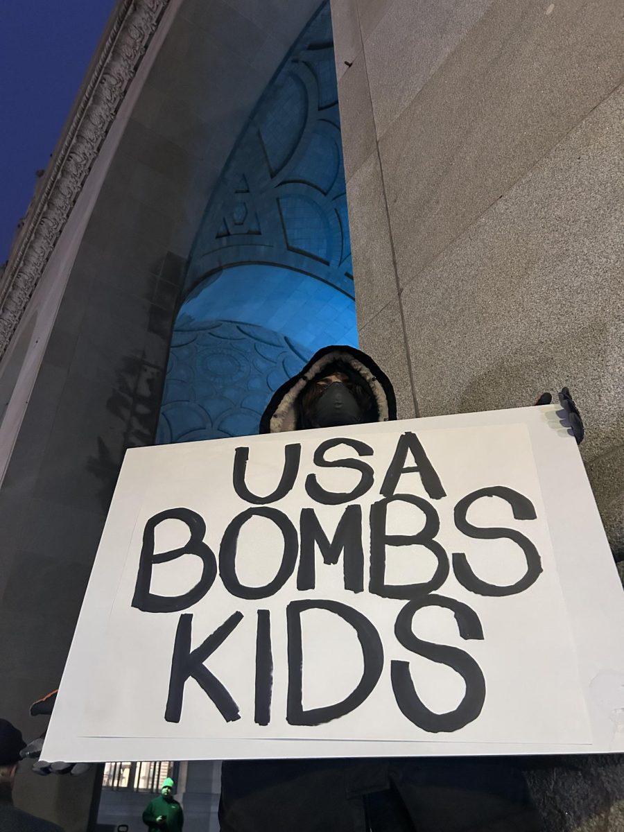 A protester holds a sign opposed to recent U.S. strikes on Iran outside the City-County building on Monday, March 2.